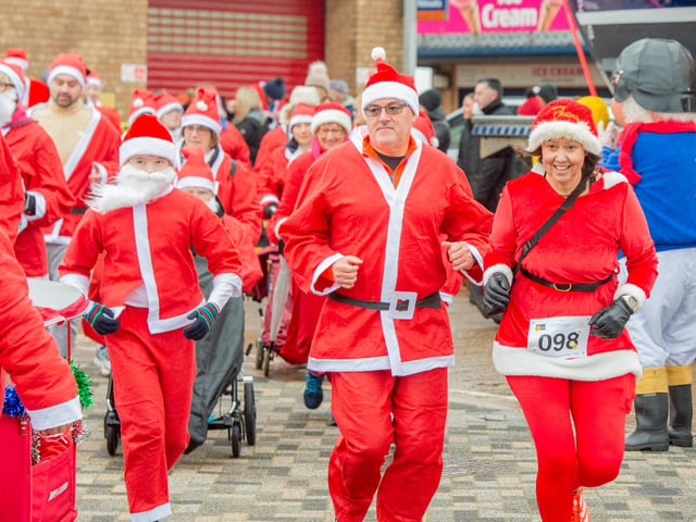 All smiles as Santas head off along the sea front.
