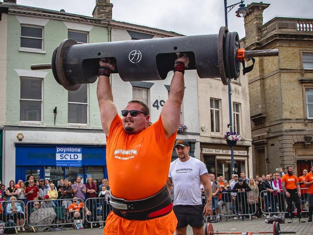Dean Mason, of Boston, lifting a 130kg log above his head.