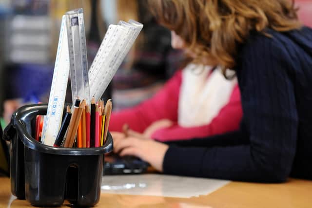 A generic stock photo shows Primary School children at work in a classroom.