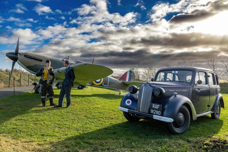 Two members of the museum in period costume, alongside the Hurricane aircraft replica.