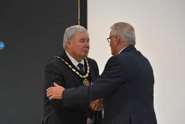 Outgoing Mayor Coun Tony Tye (right) hands over the chain of office to Coun Pete Barry. Photo: Barry Robinson.