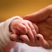 File photo dated 23/01/16 of a mother holds the hand of a new baby. Bereaved parents are being reminded by the Government to check whether they could be eligible for backdated payments. Issue date: Saturday August 5, 2023.