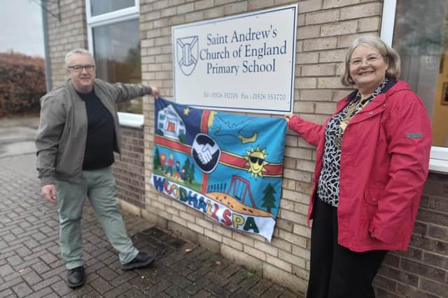 David Charles and Jenny Clarke of Woodhall Spa Rotary Club reveal the new village flag at St Andrew's School. Photo supplied