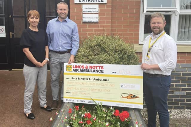 LNAA Corporate Partnership Manager receiving donation from Blue Phoenix UK team.