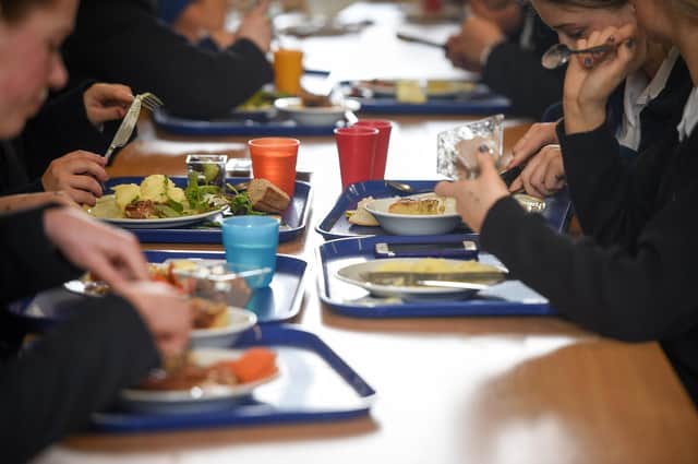Students eat their school dinner from trays and plates during lunch in the canteen at Royal High School Bath, which is a day and boarding school for girls aged 3-18 and also part of The Girls' Day School Trust, the leading network of independent girls' schools in the UK. 