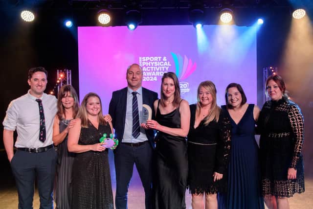 The team receiving their award at the ceremony
