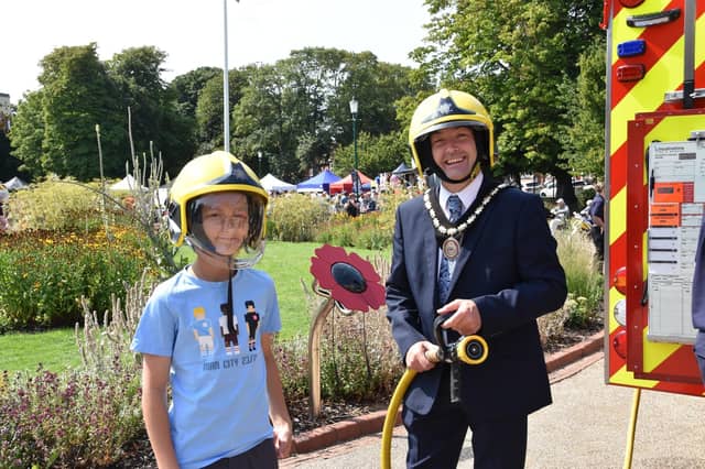 Mayor of Skegness Coun Jimmy Brookes has fun with a young 'recruit' at the Skegness Fire and Rescue engine.