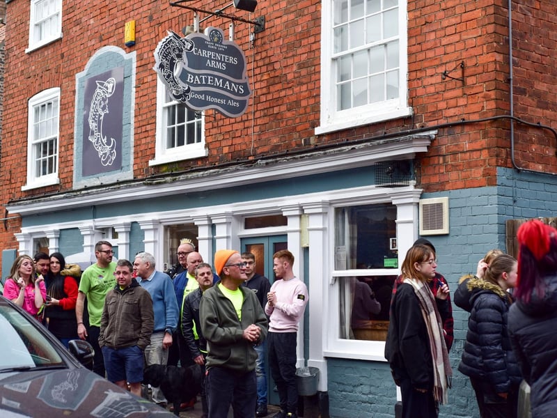 Friends gather outside The Carps pub.