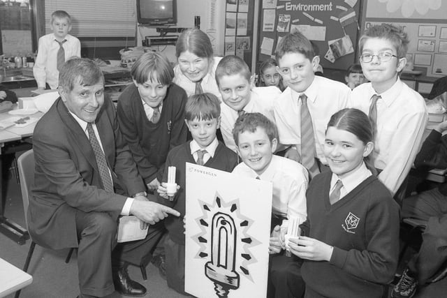 Pupils at St Mary's RC Primary School, Boston, playing host to Roy Fines, of Powergen Electricity. The school was taking part in a project which encouraged saving energy. The youngsters were given a talk by Mr Fines and were each presented with a low-energy light, an education resource pack, and surveys on saving electricity to take home and complete.