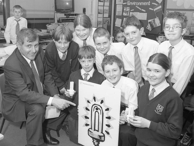 Pupils at St Mary's RC Primary School, Boston, playing host to Roy Fines, of Powergen Electricity. The school was taking part in a project which encouraged saving energy. The youngsters were given a talk by Mr Fines and were each presented with a low-energy light, an education resource pack, and surveys on saving electricity to take home and complete.