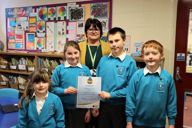 Pupils Sienna McNamara, Freya Hewitt, Connor McKenna, and Rhys Lambert with Principal Mrs Cook and the award.