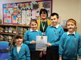 Pupils  Sienna McNamara, Freya Hewitt, Connor McKenna, and Rhys Lambert with Principal Mrs Cook and the award.