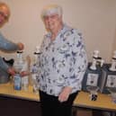 Coun Mervyn Head fills up parish councillor Maureen Corbett's bottles at the first day of their re-fill recycling project.