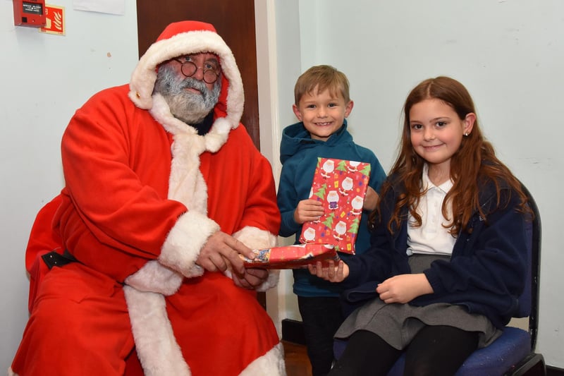 Santa handing presents to Joshua and Tia Pridmore
