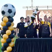 Boston United first team players hold the play off trophy aloft. Photo: David Dawson