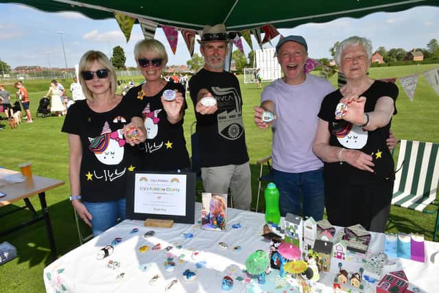 Lily's Rainbow Fund family fun day, pictured with Lily's pebbles painted by Lily's great-grandma Barbara Shaw (right) are Claire Coulam, Erica Adams, Bill Adams, and Steve Coulam.