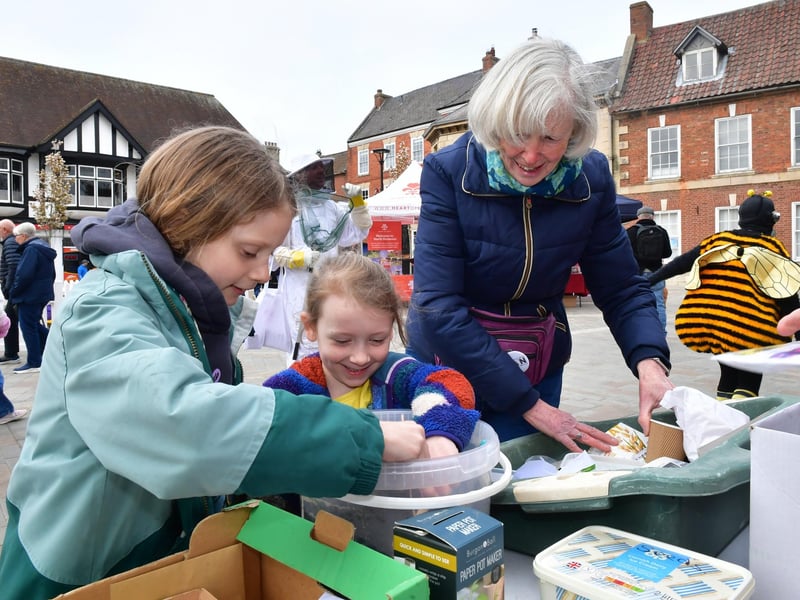 Christine Parker of Sleaford Climate Action Network, helping Jessica Watson-Smith 8 and Felicity Raikes 7. Sowing seeds at the Sleaford CAN stall. Photo: David Dawson