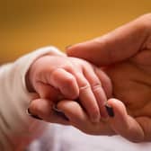 File photo dated 23/01/16 of a mother holds the hand of a new baby. Bereaved parents are being reminded by the Government to check whether they could be eligible for backdated payments. Issue date: Saturday August 5, 2023.