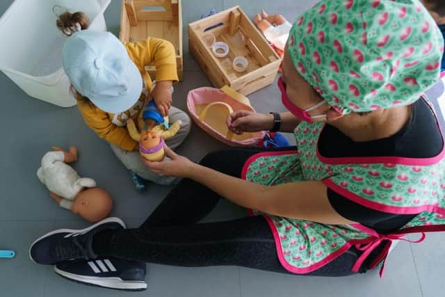 A teacher wearing a face mask attends a child at the Palotes preschool in Valladolid, on June 10, 2020. - The Palotes preschool is one of the first schools to open in the Castilla y Leon region as the country continues to loosen a national lockdown to stop the spread of the novel coronavirus. (Photo by CESAR MANSO / AFP) (Photo by CESAR MANSO/AFP via Getty Images)