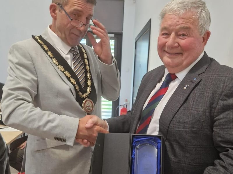 New Mayor Coun Adrian Findley gives a presentation to the outgoing Mayor Coun Pete Barry for his service.