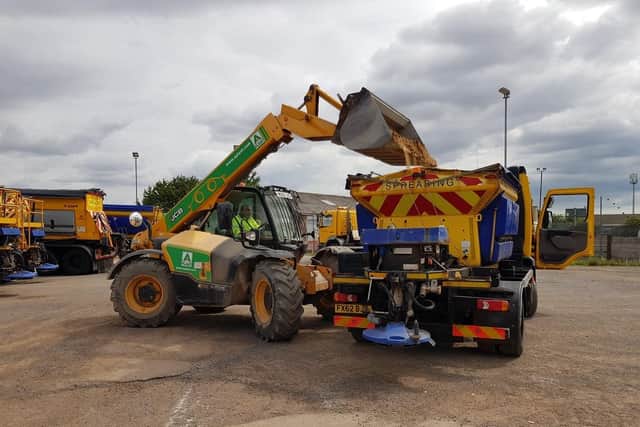Loading the gritter up with sand to help melting roads.