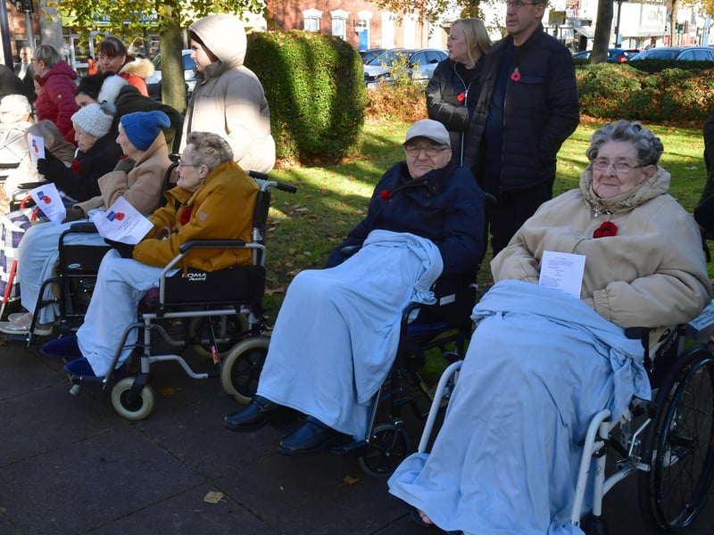 Some of the watching crowd keeping warm at the service.