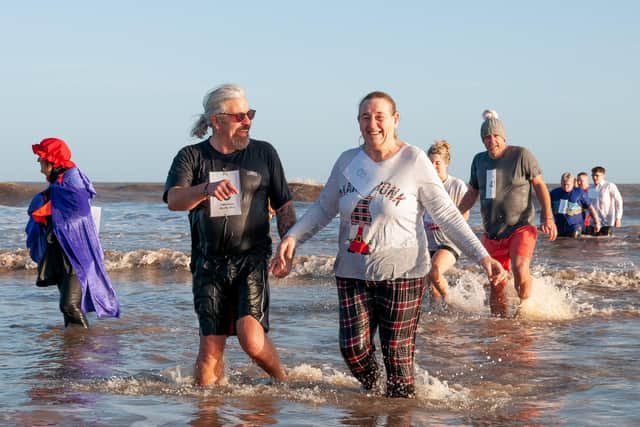 Participants emerge from the surf on Mablethorpe Beach after taking part in the 2023 Big Dip.