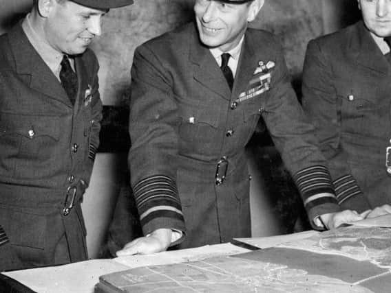 HM King George VI examining the Moehne Dam model with Group Captain Charles Whitworth (right) and Wing Commander Guy Gibson (left), Officer Commanding 617 Squadron, during his visit to Scampton, the Squadron's home, on 27 May 1943.