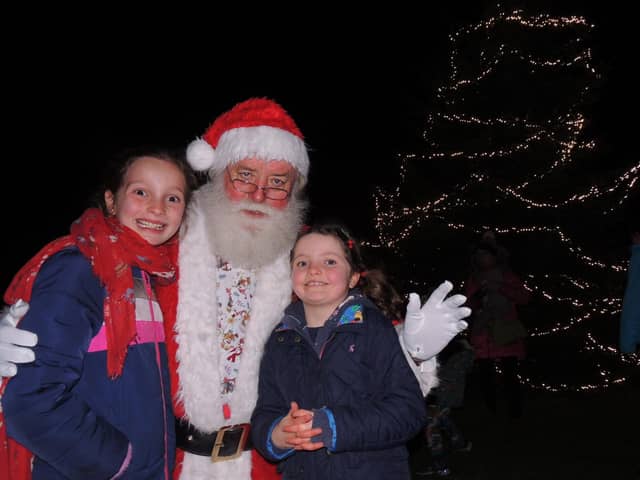 Father Christmas meets Isla, nine, and Lucy, 6, Garnett after switching on the Christmas tree lights in Navenby.