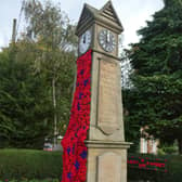 Stickford War Memorial Clock decorated with poppies for Remembrance Sunday.