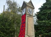 Stickford War Memorial Clock decorated with poppies for Remembrance Sunday.