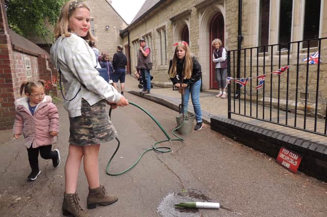 Freya and Phoebe Smith demonstrate putting out and unexploded bomb with a stirrup pump at the 1940s Day.