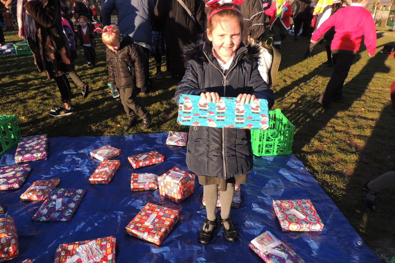 Heidi Munro, seven, finds her present from Church Lane School head, Callum Clay.