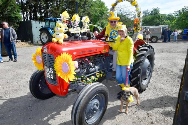 Embracing the yellow theme for Marie Curie on the tractor run are Peter Kipling and Win Gibney with dog, Max, all of South Elkington.