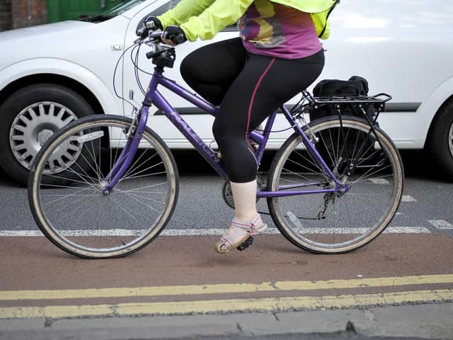 File photo dated 07/08/13 of a person cycling next to a car, as government targets to increase levels of cycling and walking in England are set to be missed, according to a new report.