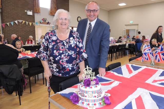 BEM medal recipient Madge Atkinson and county councillor Andrew Key judging the cake competition at the jubilee indoor picnic at Great Hale village hall.