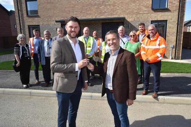 Adam Mayer, left, Managing Director of D Brown Builders, hands over the keys to the 100th completed home at The Leas to Marcus Keys, Chief Development and Commercial Officer at Amplius, with colleagues from both organisations and Boston Borough Council watching on.