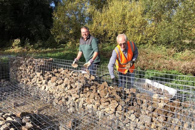 A Kingfisher nesting bank under construction. From left - Council Leader Coun Richard Wright and Executive Board Member Coun Mervyn Head lending a hand.