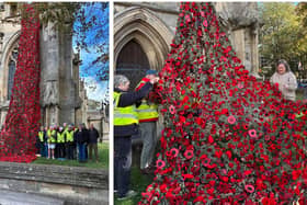 Volunteers proudly stand by their poppy cascade after wrestling it up onto St Denys' Church. Photo: Julie Butler