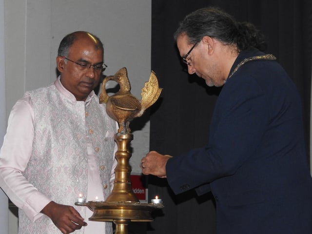 Mayor Dave Darmon lights the lamps with SICA president Nitin Noble.