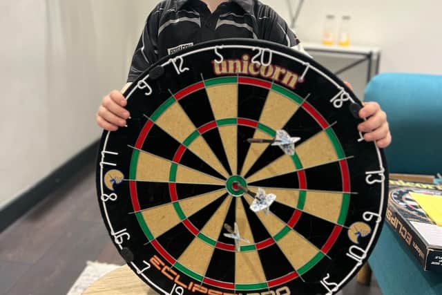 Lucas with the dartboard showing his bulls-eye.