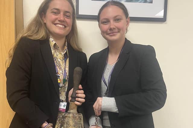 Marith Leafe, High School Head Girl and Lois Copeland, Year 12 History Prefect, holding the old school bell. Photo supplied