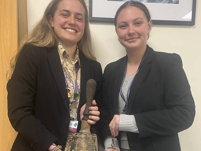 Marith Leafe, High School Head Girl and Lois Copeland, Year 12 History Prefect, holding the old school bell. Photo supplied