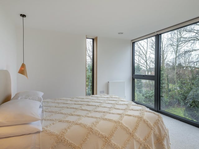 Another angle on the principal bedroom, showing the full-height windows.
