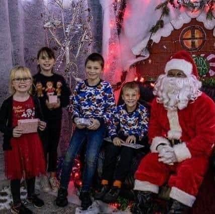 Santa Clause greets children at the Phoenix Fitness Grotto.