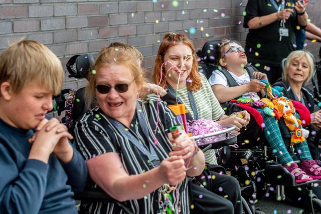 Parents, pupils and staff let off party poppers to celebrate the opening of their new school.