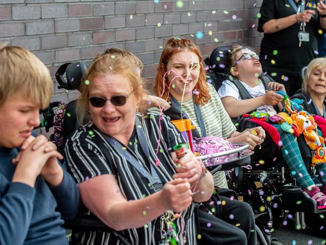 Parents, pupils and staff let off party poppers to celebrate the opening of their new school.