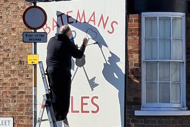Local signwriter Tony Fry restoring the old Batemans Ales advertising sign on the walls of the former Cross Keys pub in Queen Street, Horncastle.