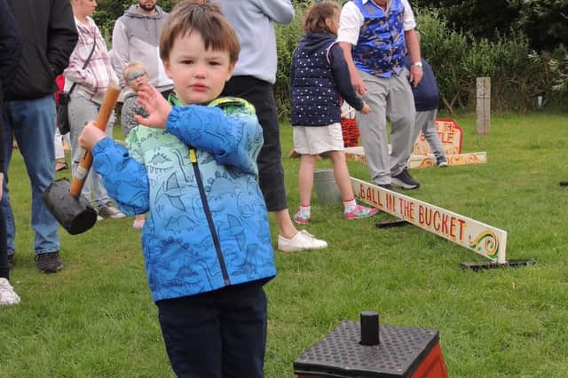 Little Charlie Adams, aged four, wields the hammer to try and make the bell ring in the fun fair games at Sleaford 1940s Day.