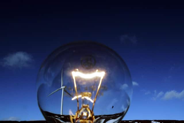 A wind turbine is pictured beside a light bulb at the Braes of Doune windfarm near Stirling, Scotland. The government has set a target for 10% of electricity to be generated from renewable sources by 2010.